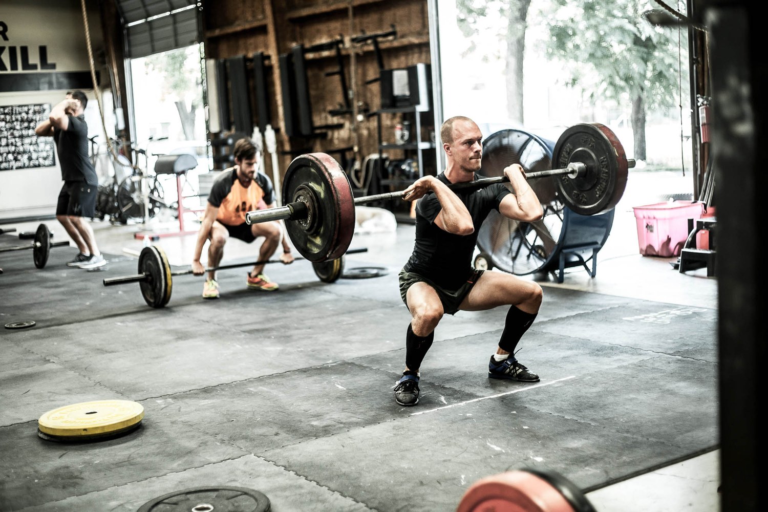 An athlete deep under a heavy barbell back squat, the kind of base this bundle builds