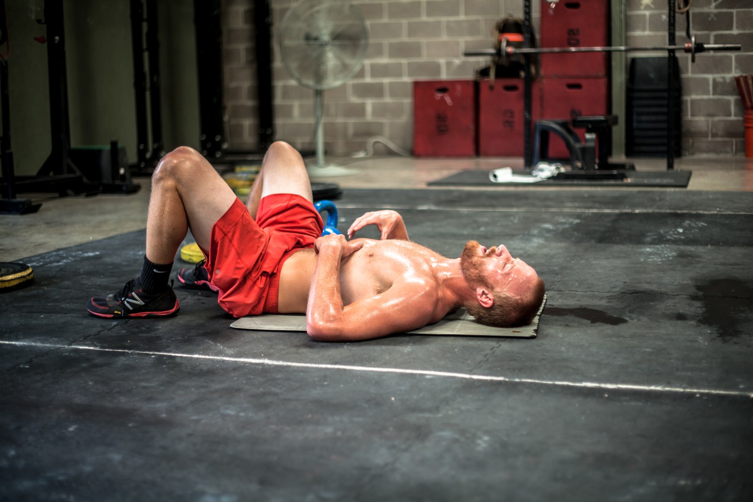 An athlete flat on the floor between efforts, gassed, the cost of conditioning that was never built on purpose