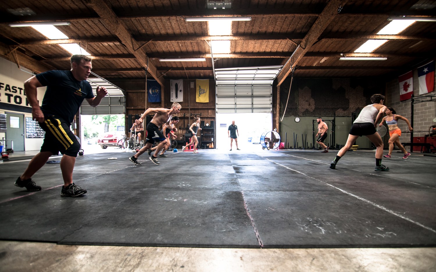 Athletes moving through a conditioning piece with nothing but the floor, minimalist training that fits anywhere