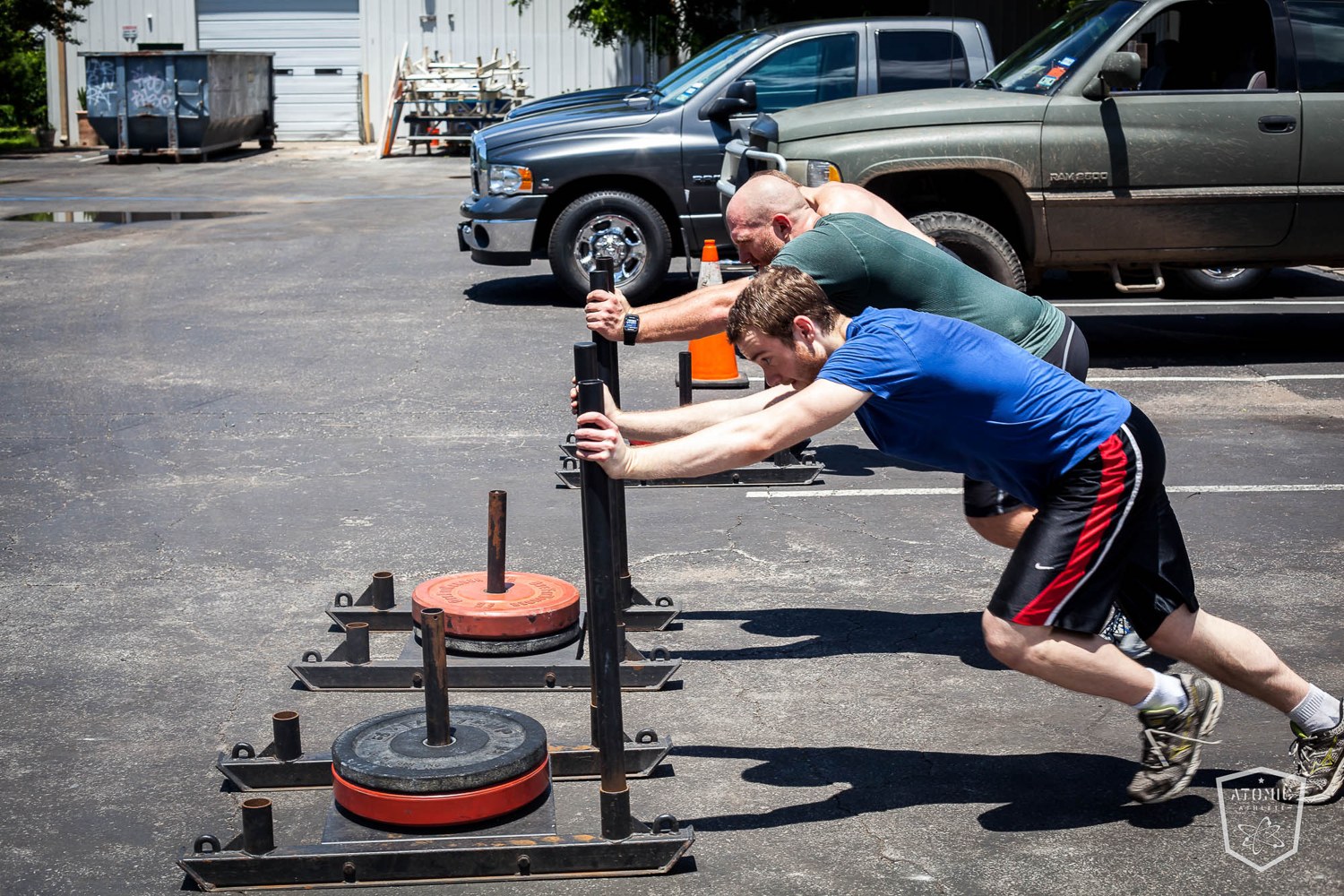 An athlete driving a heavily loaded sled, training the conditioning that holds up in the last round